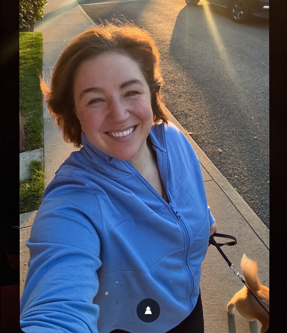 Woman walking her dog at golden hour